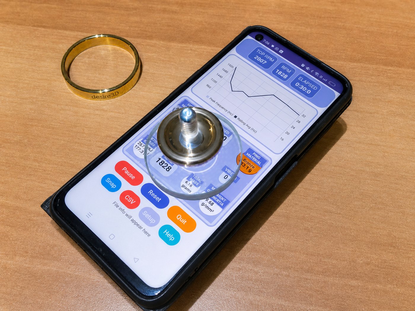 TopSpin phone setup with glass disc, brass ring, and spinning top shown from above